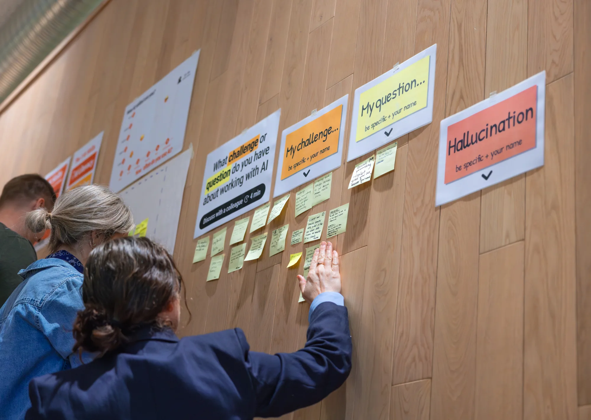 Deelnemers lezen samen de uitkomsten van een groepsoefening op de wand
